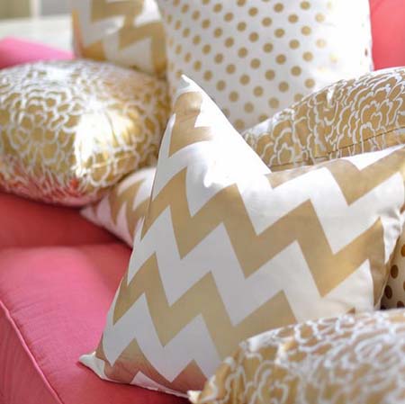 arany-fehér színű párna rózsaszín kanapén